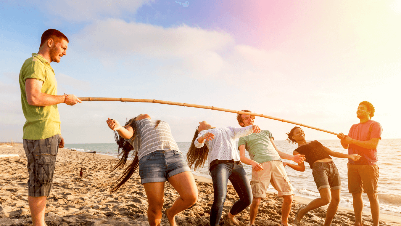 Friends Dancing Limbo at Beach