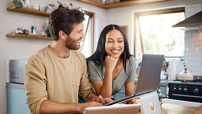 couple on laptop in sunny kitchen