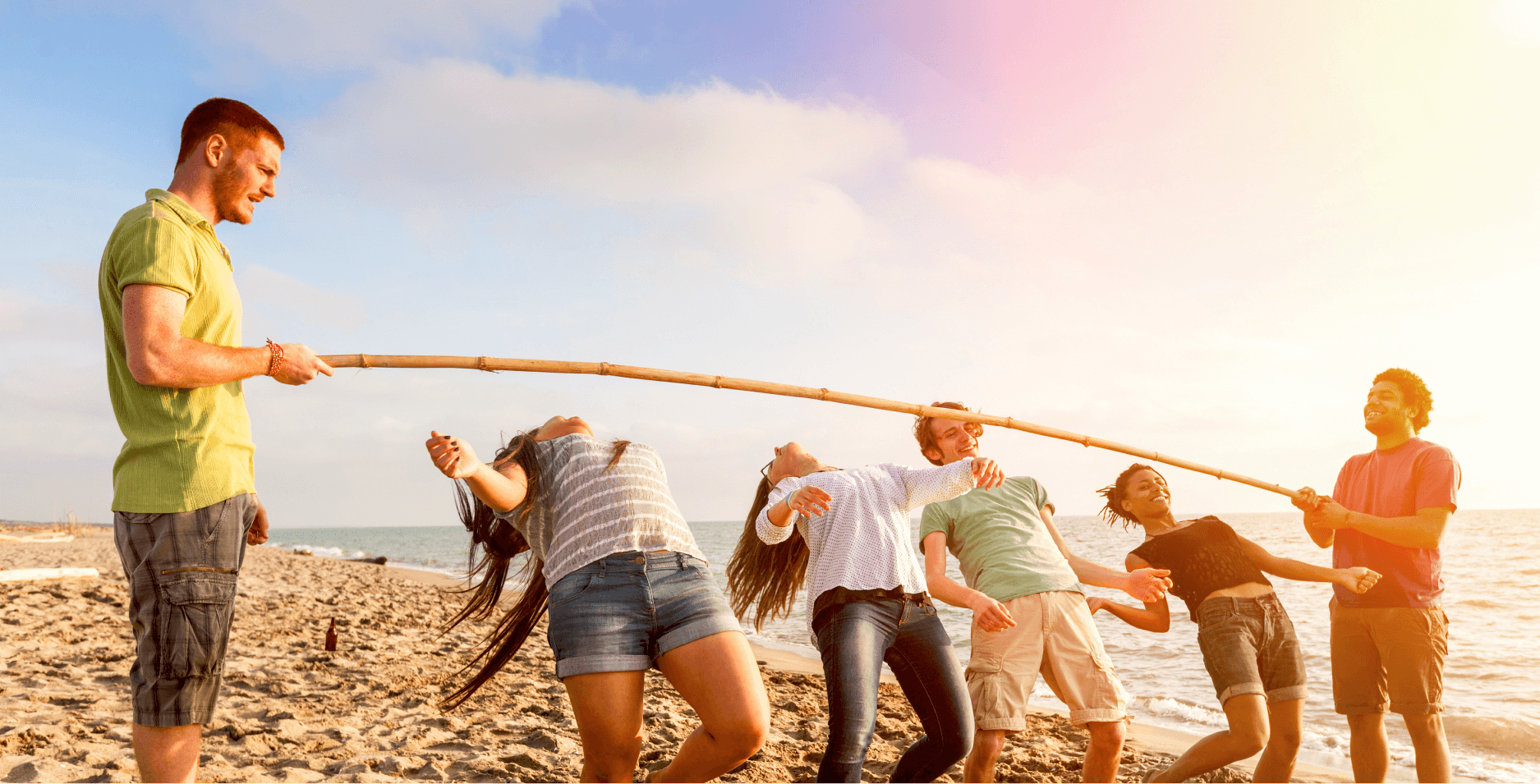 Friends Dancing Limbo at Beach