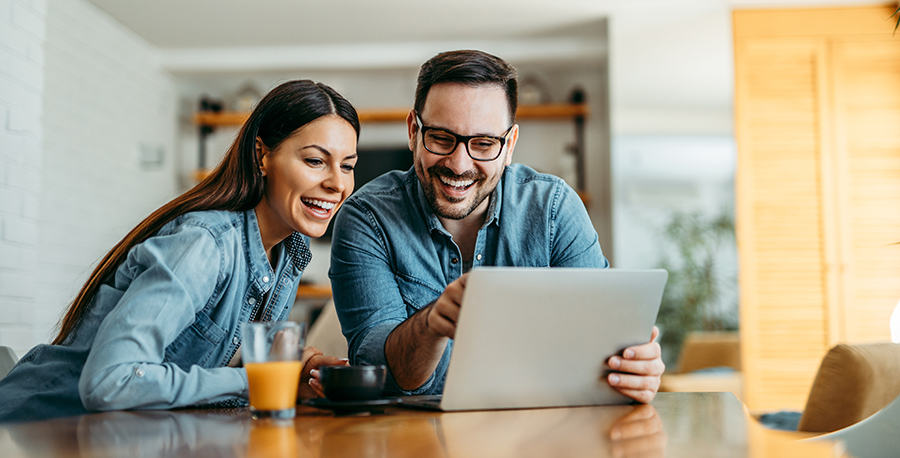 happy couple looking at tablet